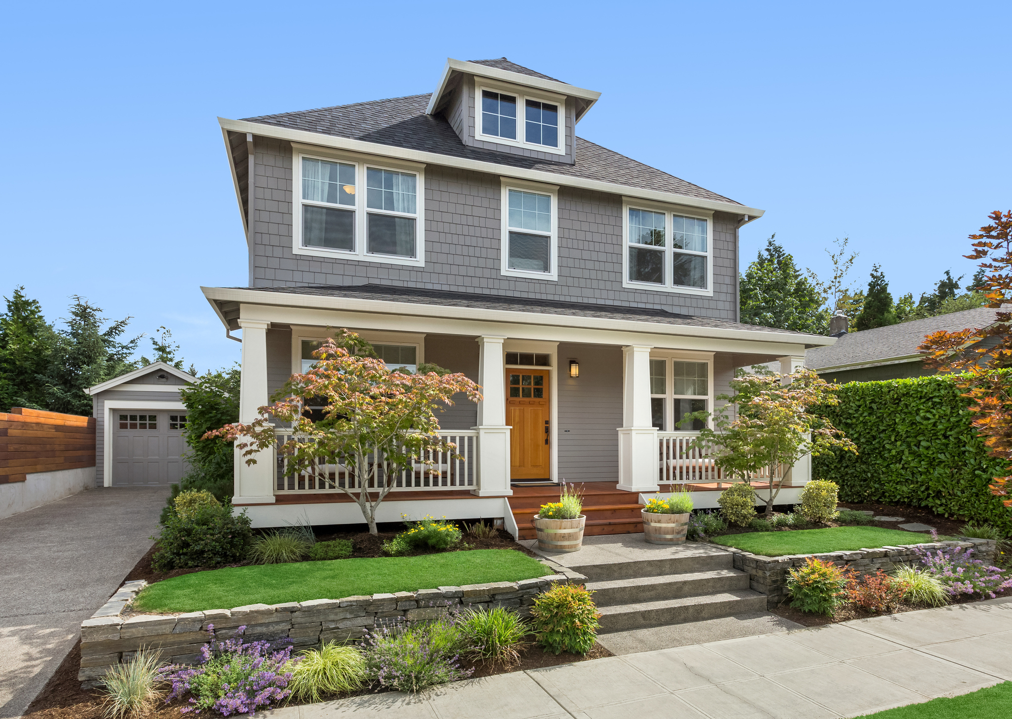 Professional exterior painting of grey house with white trim