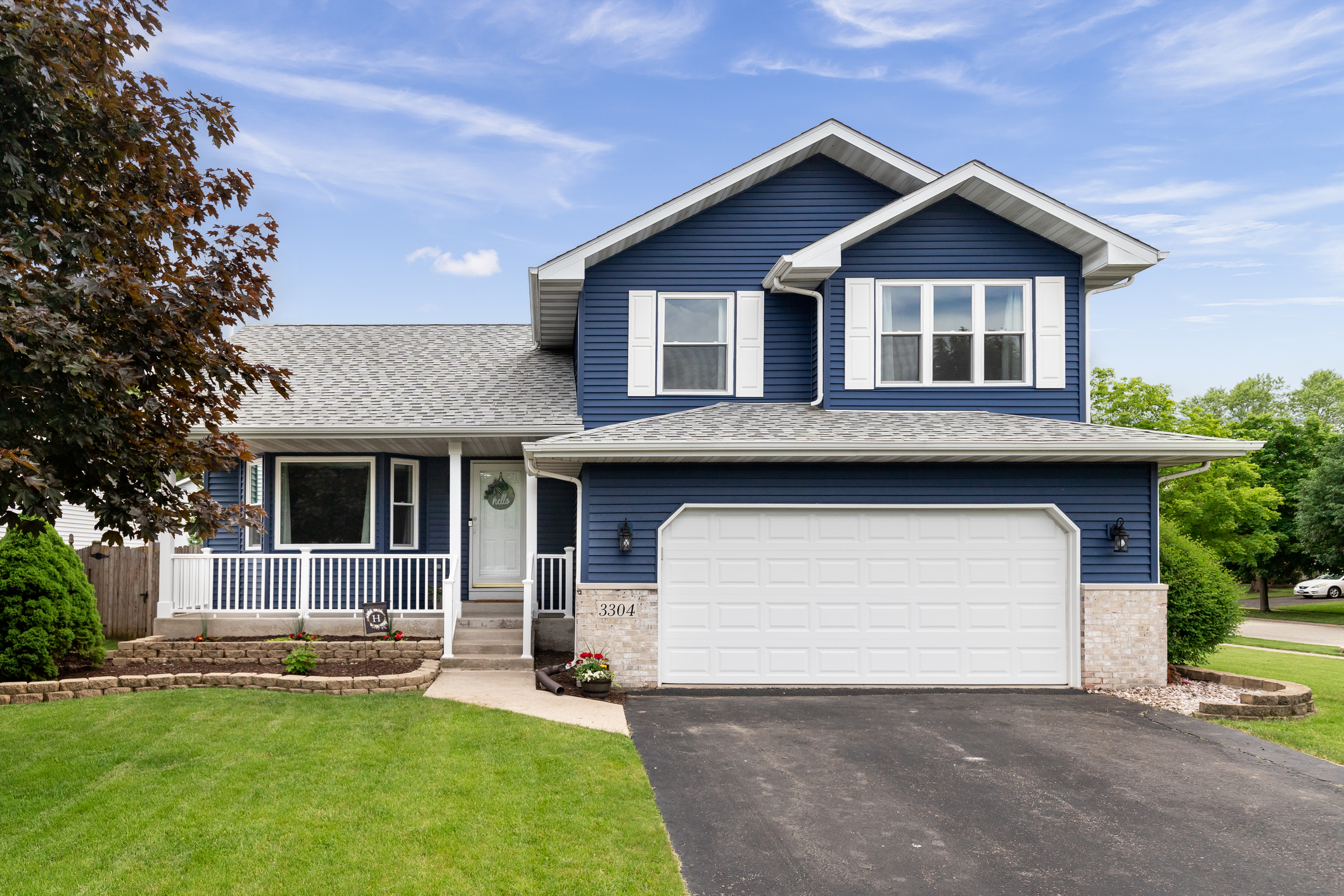 Beautifully painted deep blue siding on a suburban home with white trim.